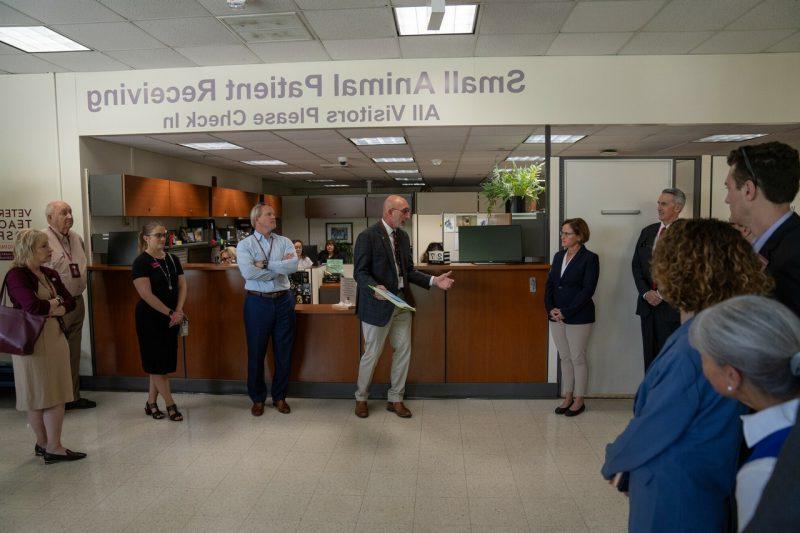 People stand in a hallway while listening to a person talk